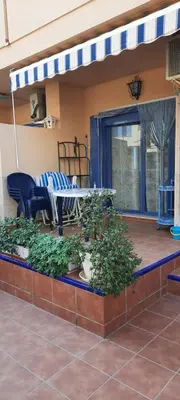 a patio with a table and chairs on a deck at Apartamento Peonia 1 in Canet de Berenguer