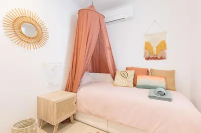 a small bedroom with a bed and a mirror at Marsalada - Ground floor front line beach apartment in Playa de Mar