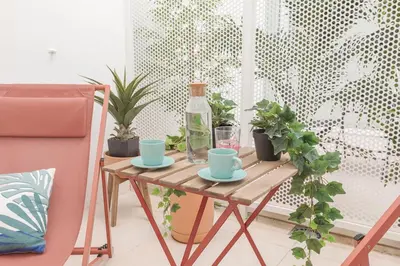 a wooden table with a bottle and cups and plants at Marsalada - Ground floor front line beach apartment in Playa de Mar