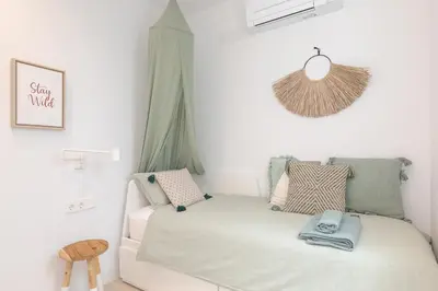 a small bedroom with a white bed and a window at Marsalada - Ground floor front line beach apartment in Playa de Mar