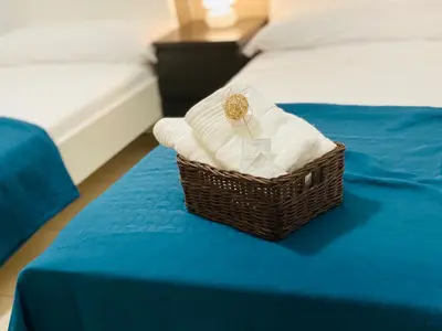 a basket of towels sitting on top of a bed at M & B Beach Apartment in Valencia