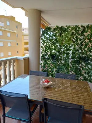 a dining table and chairs on a balcony at SUN&BEACH Moncofar in Moncófar