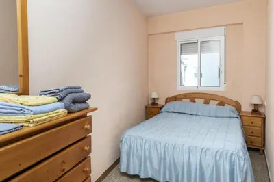 a bedroom with a bed and a dresser and a window at Solimar, 5-24 in Cullera