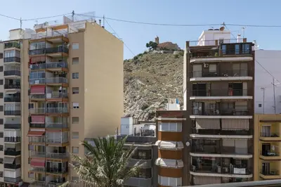 two tall buildings with a mountain in the background at Solimar, 5-24 in Cullera