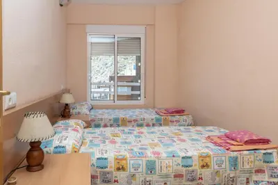 a bedroom with two beds and a window at Solimar, 5-24 in Cullera