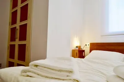 a bedroom with a bed with white sheets and a window at Hola Valencia - Holiday Apartments in Valencia