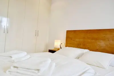 a white bed with white pillows and a wooden headboard at Hola Valencia - Holiday Apartments in Valencia