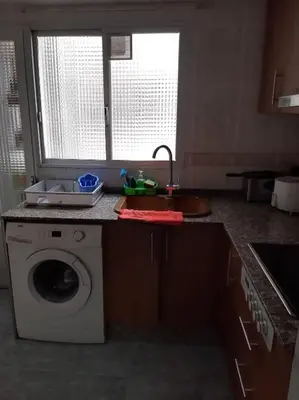 a kitchen with a washing machine and a sink at habitación pequeña en piso compartido con 2 adultos in Valencia