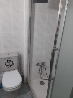 a small bathroom with a toilet and a shower at habitación pequeña en piso compartido con 2 adultos in Valencia