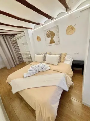 two beds in a room with white walls and wood floors at EL RINCÓN deMANUELA in Requena
