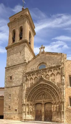 a large stone building with a clock tower on top at EL RINCÓN deMANUELA in Requena