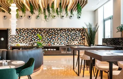 a restaurant with tables and chairs and a flat screen tv at Ilunion Valencia 4 in Valencia