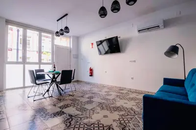 a living room with a blue couch and a table at Arenas beach in Valencia
