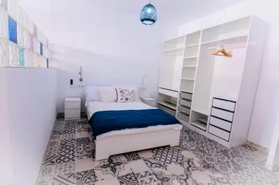 a small bedroom with a bed and shelves at Arenas beach in Valencia