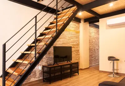 a living room with a staircase and a tv at Marittimo Apartments in Valencia