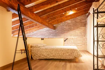 a bedroom with a bed and a brick wall at Marittimo Apartments in Valencia
