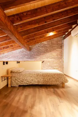 a bedroom with a bed and a brick wall at Marittimo Apartments in Valencia