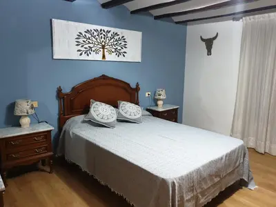 a bedroom with a bed and a blue wall at Casa Castillo de la Estrella in Segorbe