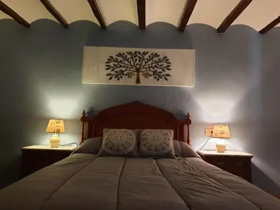 a bedroom with a bed with two lamps on both sides at Casa Castillo de la Estrella in Segorbe