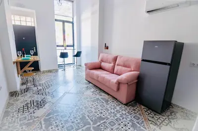a living room with a pink couch and a refrigerator at Arenas beach 2 in Valencia