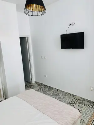 a white bedroom with a bed and a light at Arenas beach 2 in Valencia