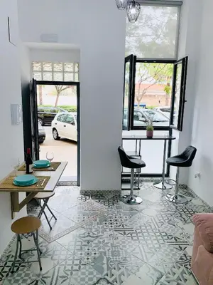 a living room with a table and chairs on a tile floor at Arenas beach 2 in Valencia