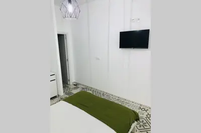a living room with a green couch and a tv at Arenas beach 3 in Valencia
