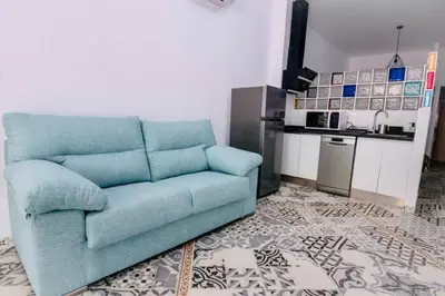 a blue couch in a living room with a kitchen at Arenas beach 3 in Valencia