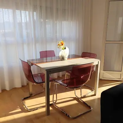 a table with two chairs and a vase of flowers on it at Aitana in Fortaleny