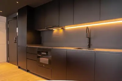 a kitchen with black cabinets and a stove at Valencia Luxury - Sea Port II in Valencia