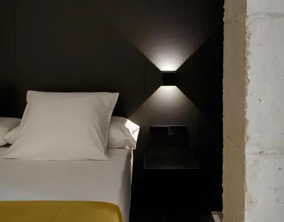 a bedroom with a bed with a light on the wall at Fetén in Valencia