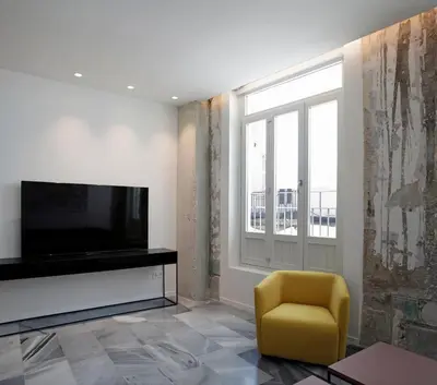 a living room with a television and a yellow chair at Fetén in Valencia