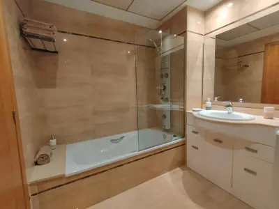a bathroom with a shower and a sink and a tub at NON STRESS Arena Primera línea de Playa in Valencia