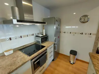 a kitchen with a sink and a refrigerator at NON STRESS Arena Primera línea de Playa in Valencia
