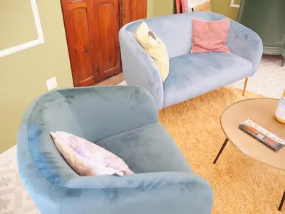 a living room with a blue chair and a table at Blaucel Cafè i Habitacions in Cullera