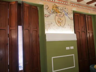 a room with two wooden doors and a wall at Blaucel Cafè i Habitacions in Cullera