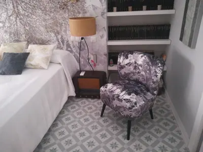 a bedroom with a chair next to a bed at Blaucel Cafè i Habitacions in Cullera