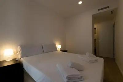 a bedroom with a white bed with towels on it at Apartamentos Mercado Central in Valencia