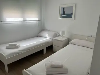 two beds in a small room with white walls at Apartamentos Mercado Central in Valencia