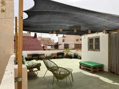 a patio with a table and chairs on a roof at Apartamento a 400m de la playa, Puerto de Sagunto in Puerto de Sagunto