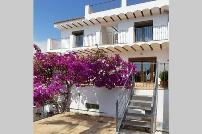 a white building with purple flowers and a staircase at Ca Buganvilla. El corazón de la huerta valenciana in Meliana