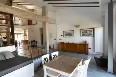 a kitchen and dining room with a wooden table and chairs at Ca Buganvilla. El corazón de la huerta valenciana in Meliana