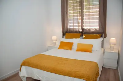 a bedroom with a large white bed with yellow pillows at Soraya's Place - Chopín 1 in Valencia