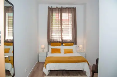a bedroom with a bed with yellow pillows and a window at Soraya's Place - Chopín 1 in Valencia