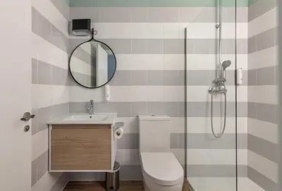 a bathroom with a shower and a toilet and a mirror at Líbere Valencia Jardín Botánico in Valencia