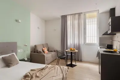 a hotel room with a bed and a living room at Líbere Valencia Jardín Botánico in Valencia
