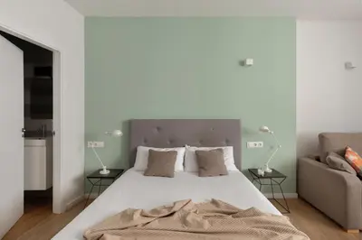 a bedroom with a large bed and a couch at Líbere Valencia Jardín Botánico in Valencia