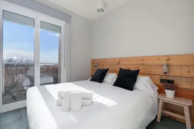 a bedroom with a white bed with a large window at Your home at Valencia, Marina Real in Valencia