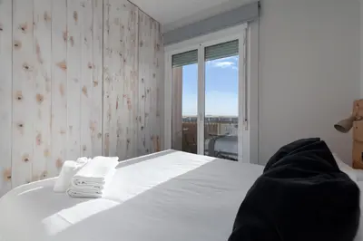 a bedroom with a white bed and a large window at Your home at Valencia, Marina Real in Valencia