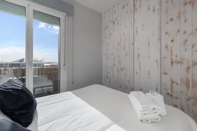 a bedroom with a white bed and a large window at Your home at Valencia, Marina Real in Valencia